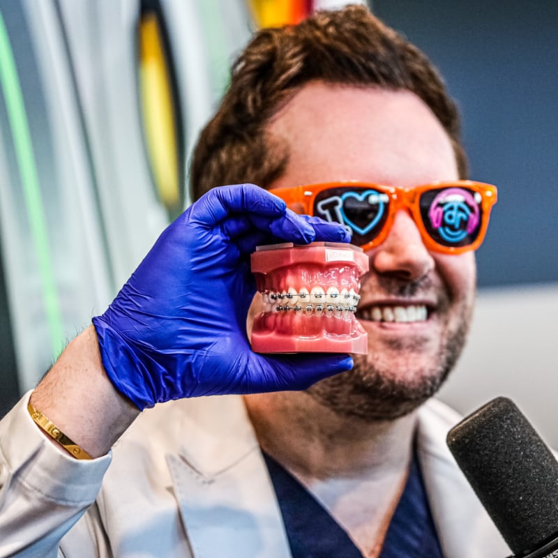 dr. dobie holding a set up ceramic teeth.