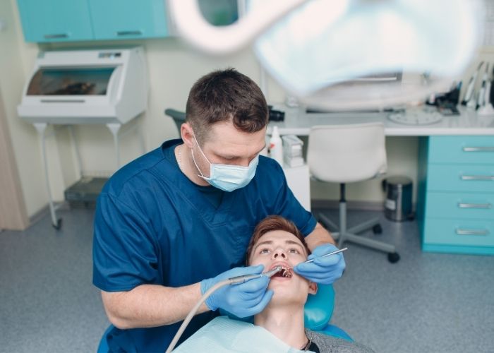 orthodontist working on a man's mouth