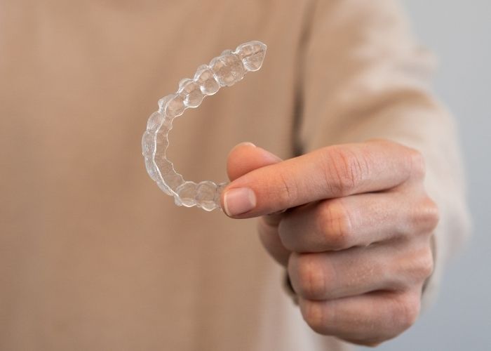 man holding up a retainer for after braces